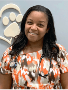 Dr. Tiffany smiling in front of a pet-themed wall